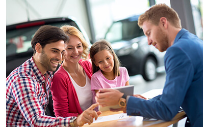 Happy family in car dealership, signing a car lease contract